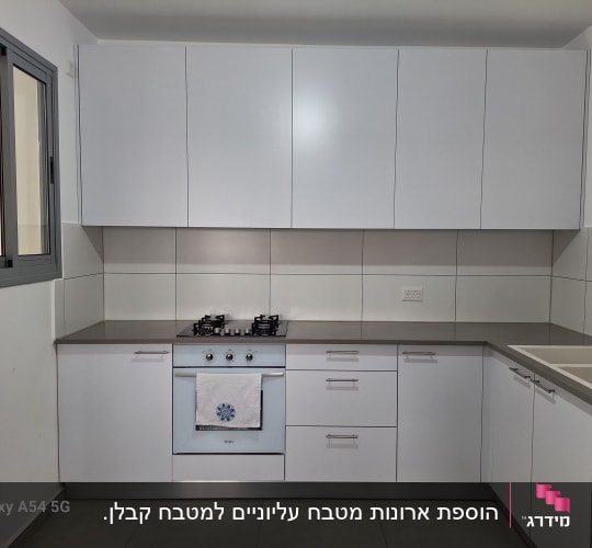 מטבח מודרני עם ארונות לבנים וכיריים גז